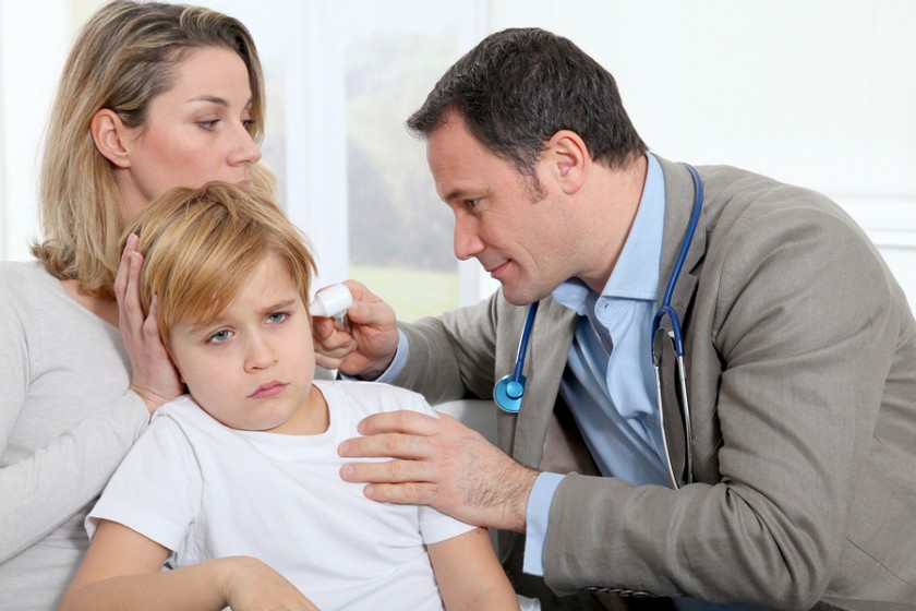 Doctor checking little boy's ear infection